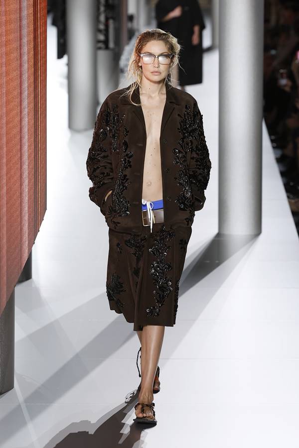 Gigi Hadid na passarela de moda da Miu Miu. Ela usa bermuda de cintura baixa e blazer marrom - Metrópoles