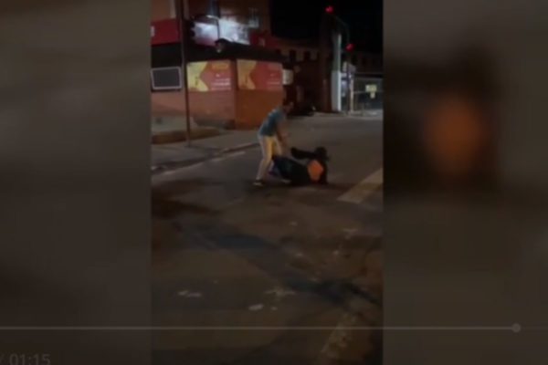 Foto colorida mostra mulher sendo agredida no meio da rua