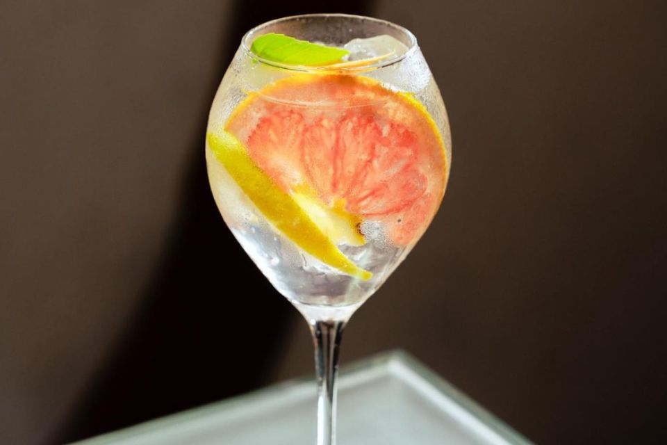 Foto colorida de um drink com laranja - Metrópoles
