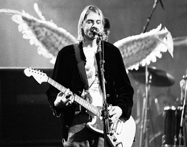 Kurt Cobain canta em palco com asas as suas costas - Metrópoles
