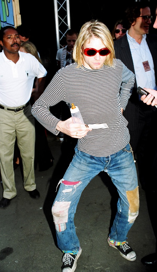 Kurt Cobain com blusa listrada e calça jeans remendada - Metrópoles