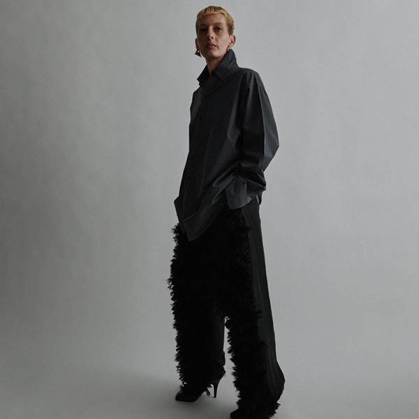 Na coleção de estreia da marca própria de Phoebe Philo, modelo usa look preto com plumas na calça - Metrópoles