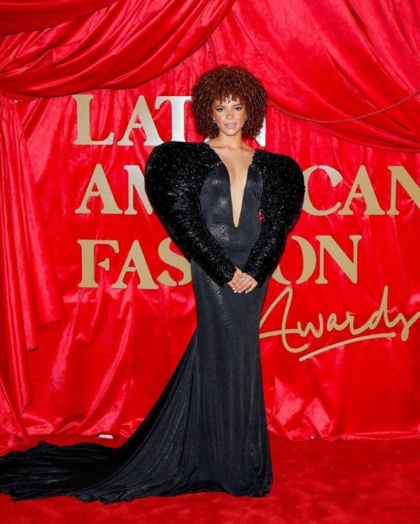 Na imagem com cor, uma mulher negra posando no tapete vermelho do Latin American Fashion Awards - Metrópoles