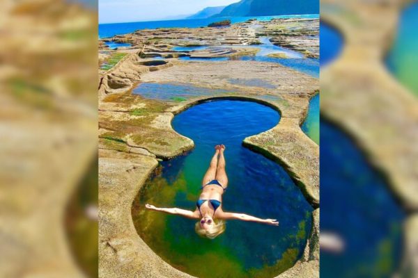 Imagem colorida de pessoa tomando banho em piscina natural - Metrópoles