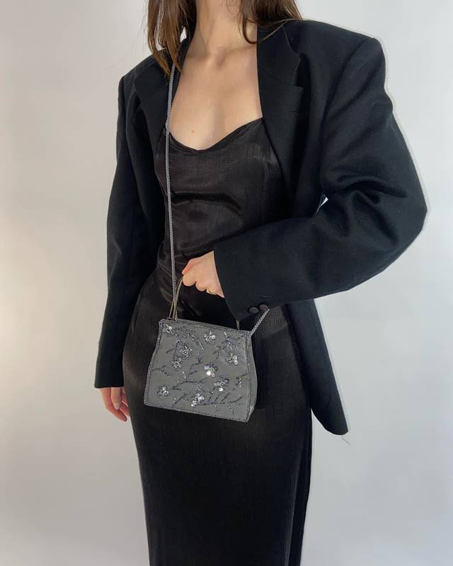 Mulher exibe look preto com bolsa cinza - Metrópoles
