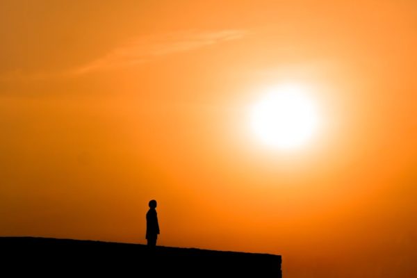 imagem amarela pôr do sol com silhueta de uma pessoa