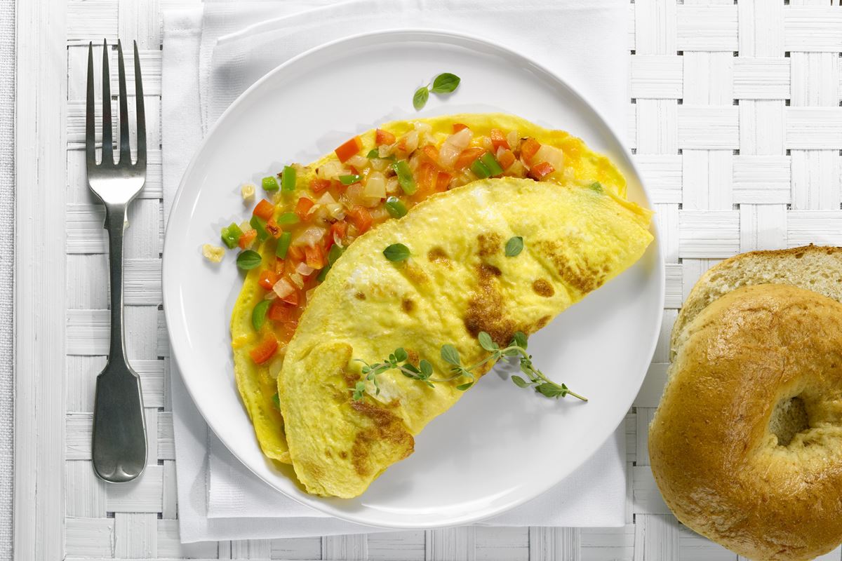 Foto colorida de omelete com legumes em um prato branco - Metrópoles