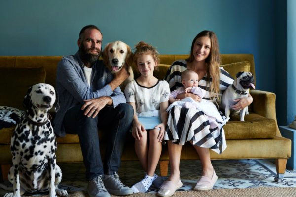 Família sentada em sofá com cachorros 