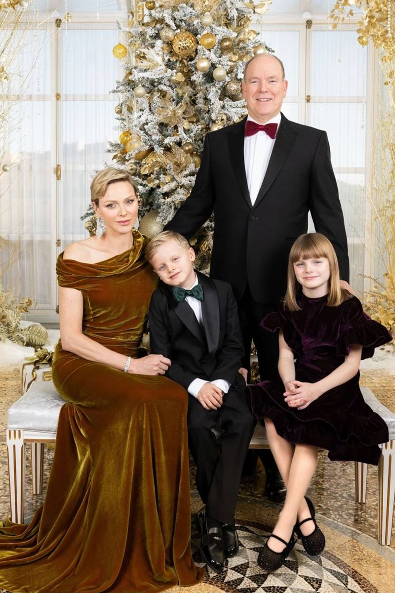 Foto de mulher e homem com um menino e uma menina. Eles estão em um ambiente com árvore de Natal e arranjos dourados - Metrópoles
