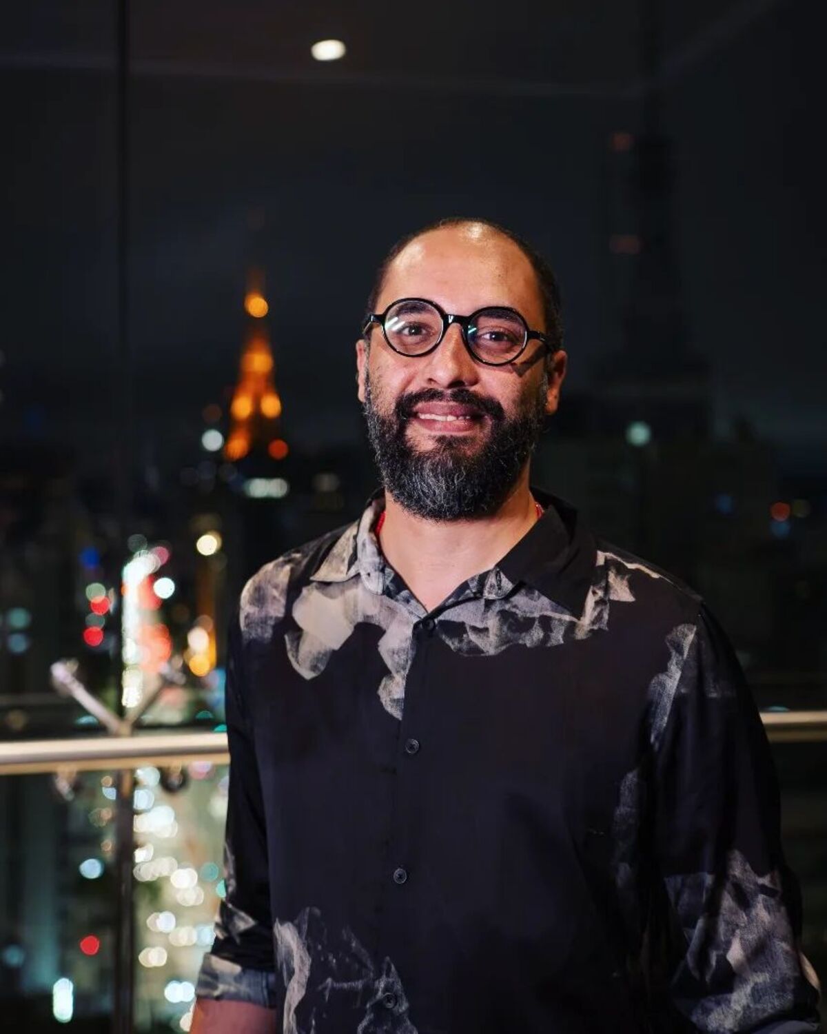 Brunno Almeida Maia professor de óculos barba e camisa azul