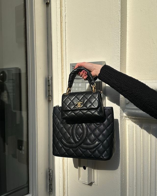 Close em mão segurando bolsas pretas da Chanel - Metrópoles