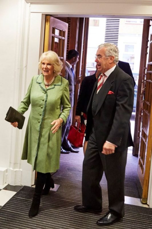 Foto de mulher idosa, com roupa verde, ao lado de homem idoso com terno. Eles passaram por uma porta - Metrópoles