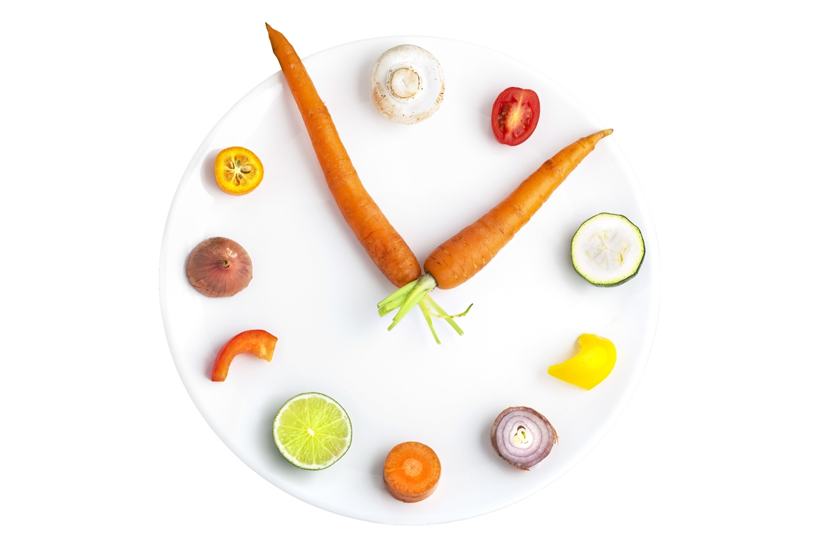 Foto colorida de relógio com ponteiros feitos de cenoura e vegetais são os números - Metrópoles