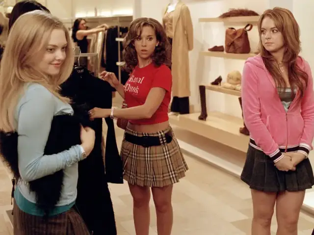 Na imagem com cor, cena do filme Meninas Malvadas com elas olhando peças de moda - Metrópoles