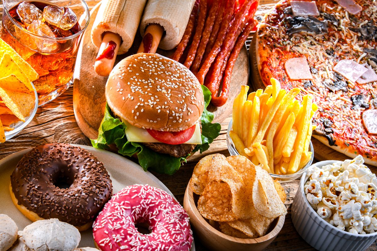 Alimentos que prejudicam a saúde dispostos em uma mesa