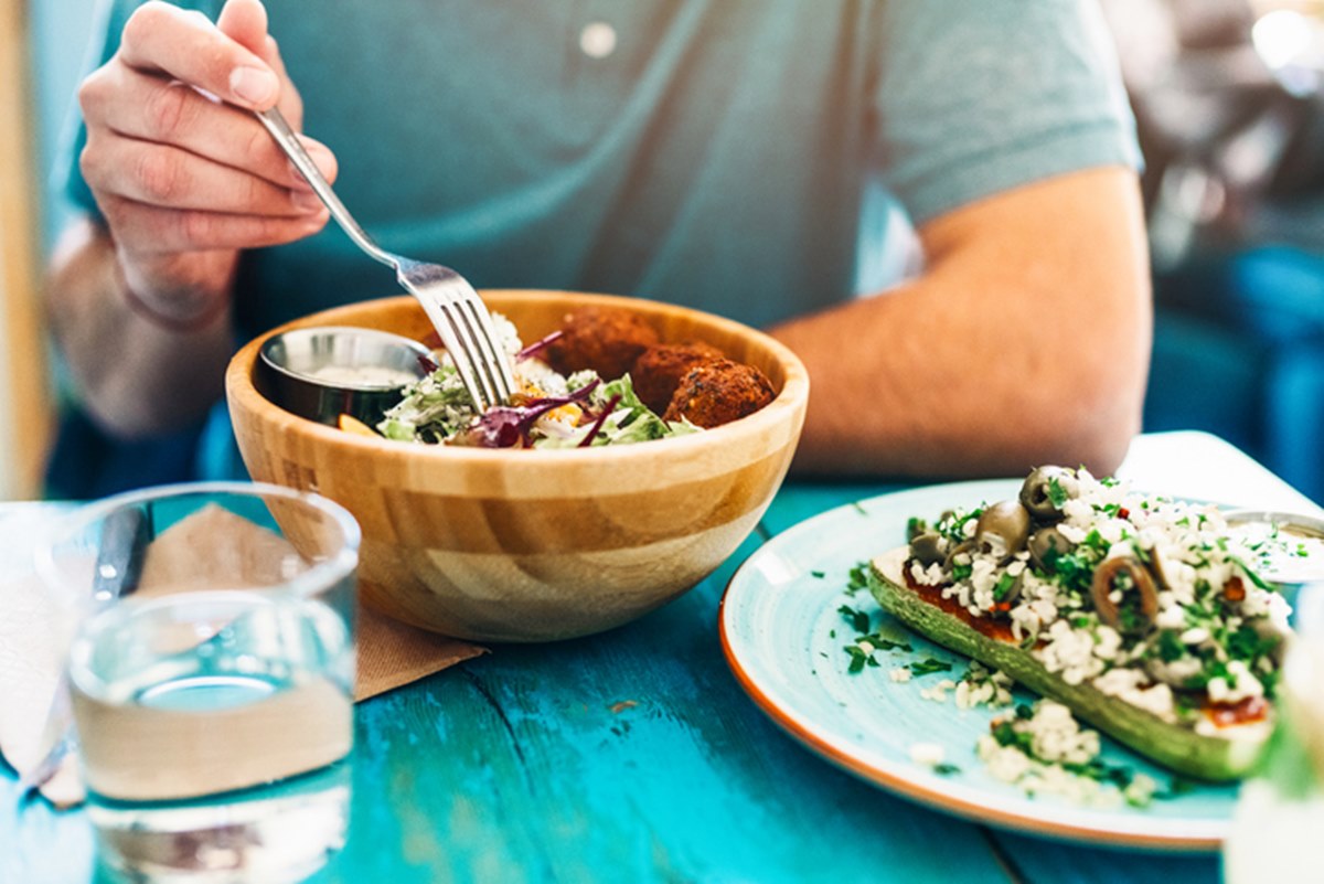 Imagem ilustrativa de homem em dieta vegana comendo refeição com vegetais - Metrópoles