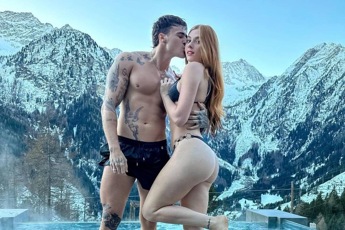 Alex Mapeli e Flávia Charallo. Ele beija o rosto dela em local paradisíaco - Metrópoles