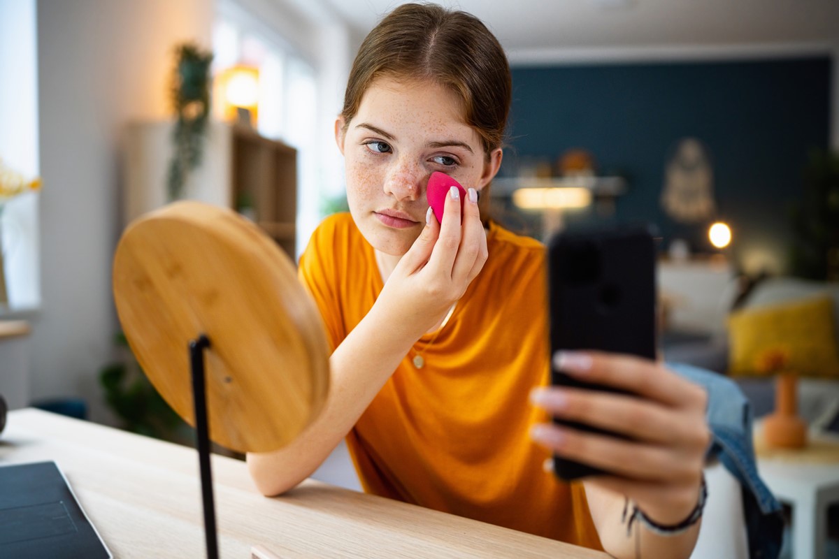 Adolescente manda mensagens de texto no celular enquanto faz maquiagem - Metrópoles