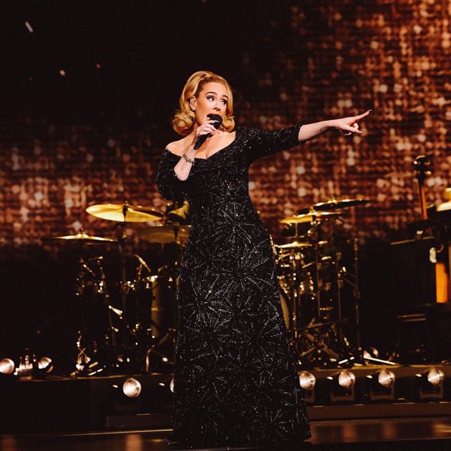 Na imagem com cor, a cantora Adele durante apresentação em Las Vegas - Metrópoles