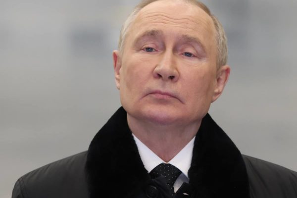Imagem colorida mostra Putin, presidente da Rússia, usando casaco G20 - Metrópoles