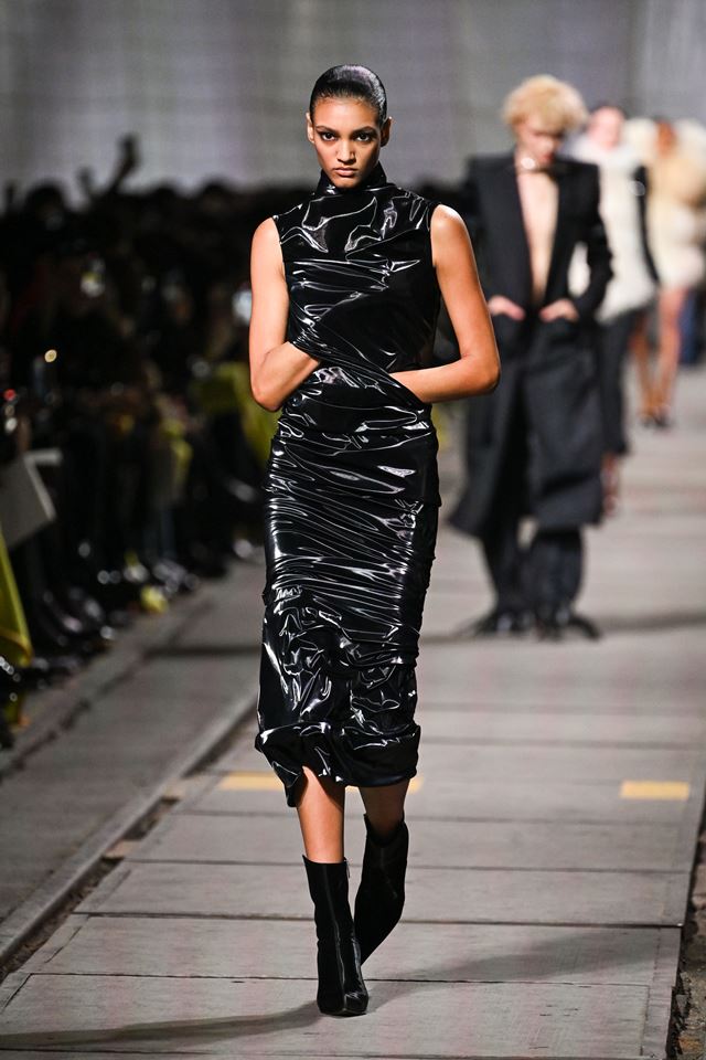 Na passarela, modelo usa vestido preto plastificado - Metrópoles
