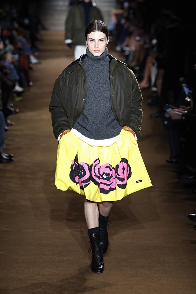 Na passarela da Miu Miu, modelo usa saia amarela com estampa rosa, além de casaco azul com gola alta e jaqueta preta - Metrópoles