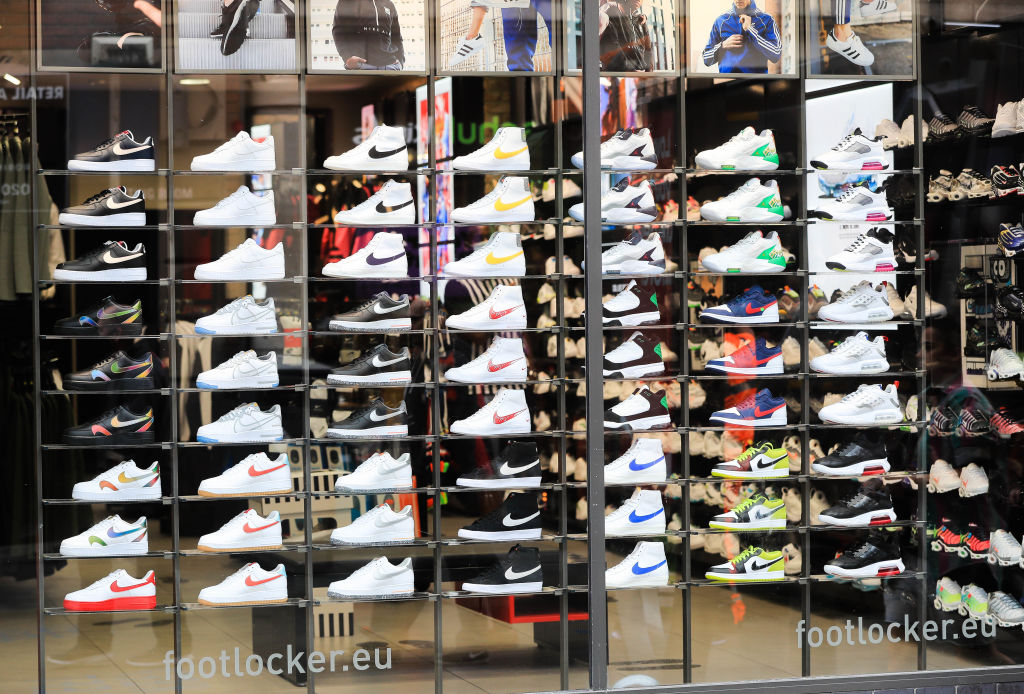 Imagem de calçados variados em vitrine de loja.