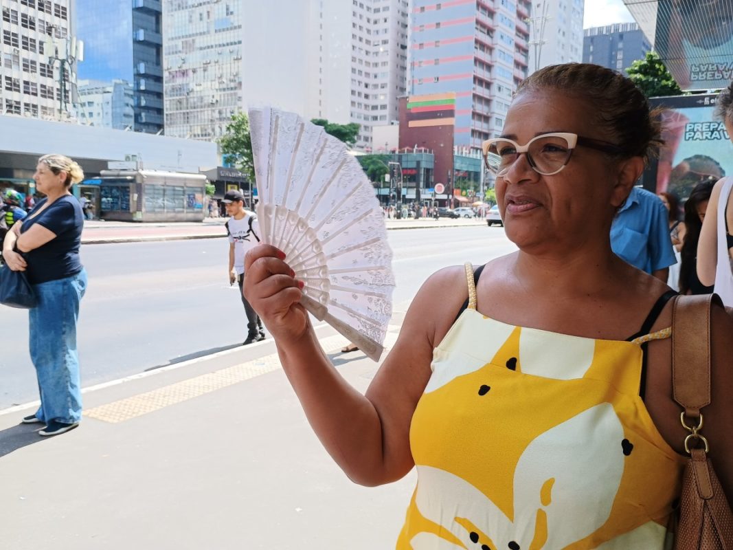 Mulher com leque em avenida - Metrópoles