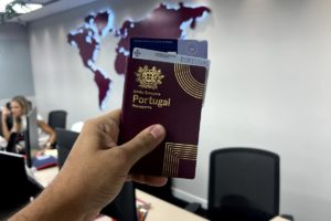 Fotografia colorida de um homem com um passaporte na mão | cidadania portuguesa