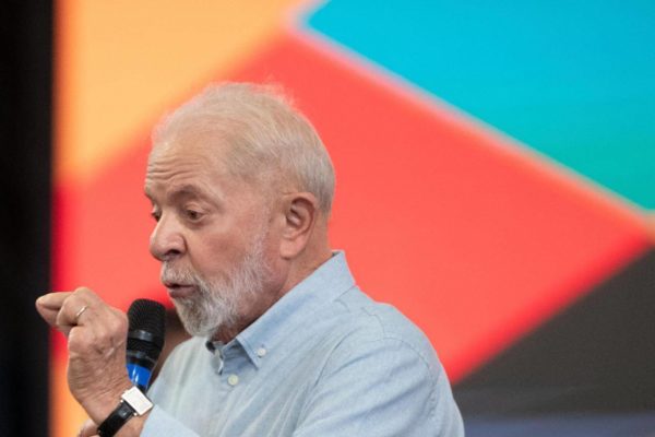 Imagem colorida do presidente Lula falando ao microfone - Metrópoles