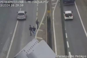 Imagem colorida de policiais prendendo um homem na rodovia. Metrópoles