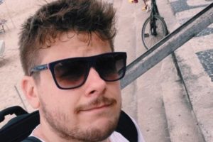 Homem de barba rala e óculos escuros - Metrópoles