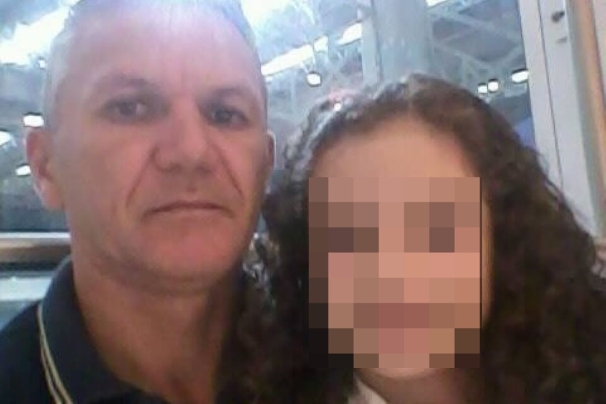 Homem branco ao lado de criança (rosto está borrado) com cabelos escuros, cacheados e logos
