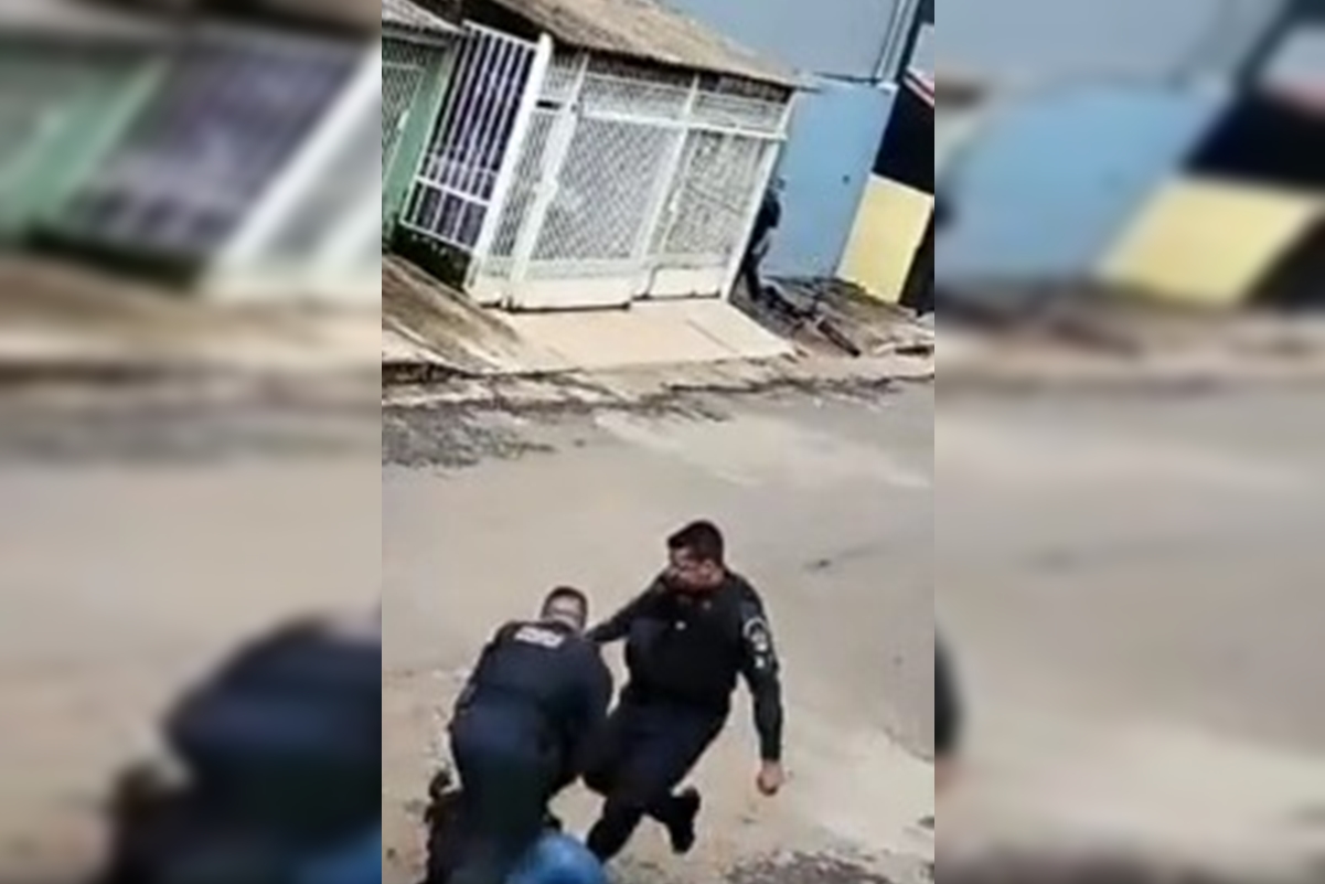 Imagem colorida de vídeo em que PM dá chute em mulher durante abordagem