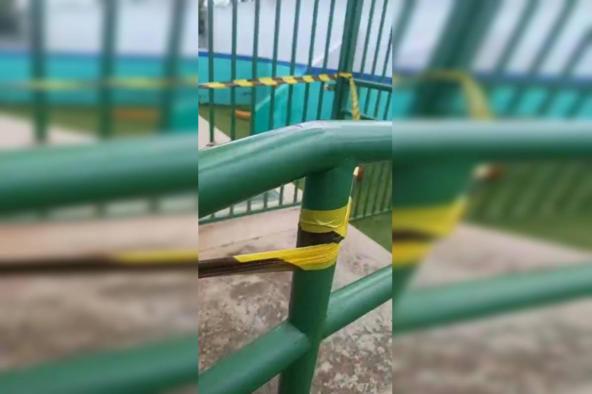 Foto colorida de grade com lacre para interditar