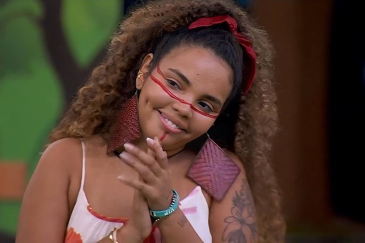 foto colorida de Giovanna Pitel, do BBB 24, uma mulher negra de cabelos cacheados sorrindo com uma mão na outra como quem bate palmas - metrópoles