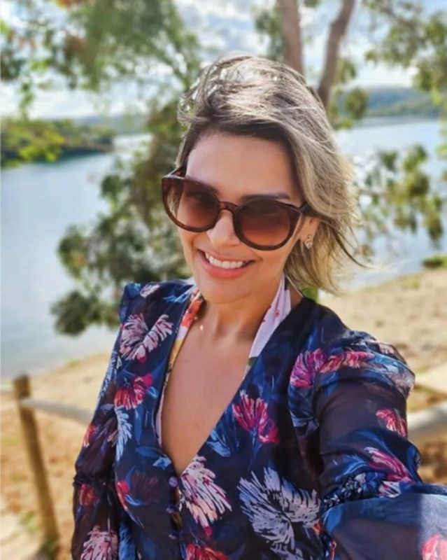 mulher sorrindo de óculos escuros