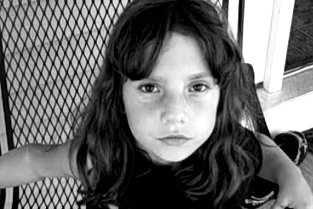 Na imagem em preto e branco, menina está com o cabelo solto e olha para a câmera - Metrópoles