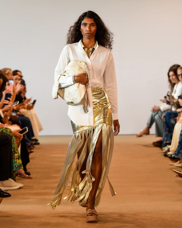 Look com camisa branca, saia com franjas e metalizado. Modelo na passarela da marca Lilly Sarti no São Paulo Fashion Week N57 - Metrópoles