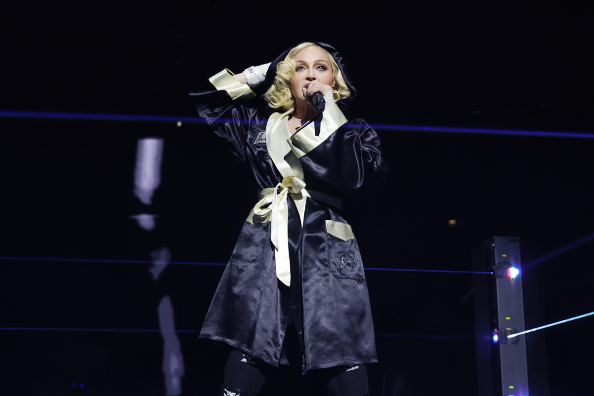Foto de mulher em um palco segurando um microfone - Metr&oacute;poles