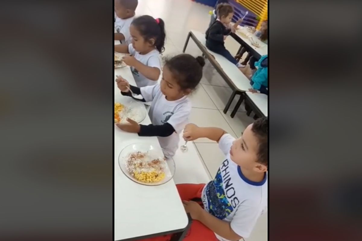 Foto colorida de duas crianças comendo - Metrópoles