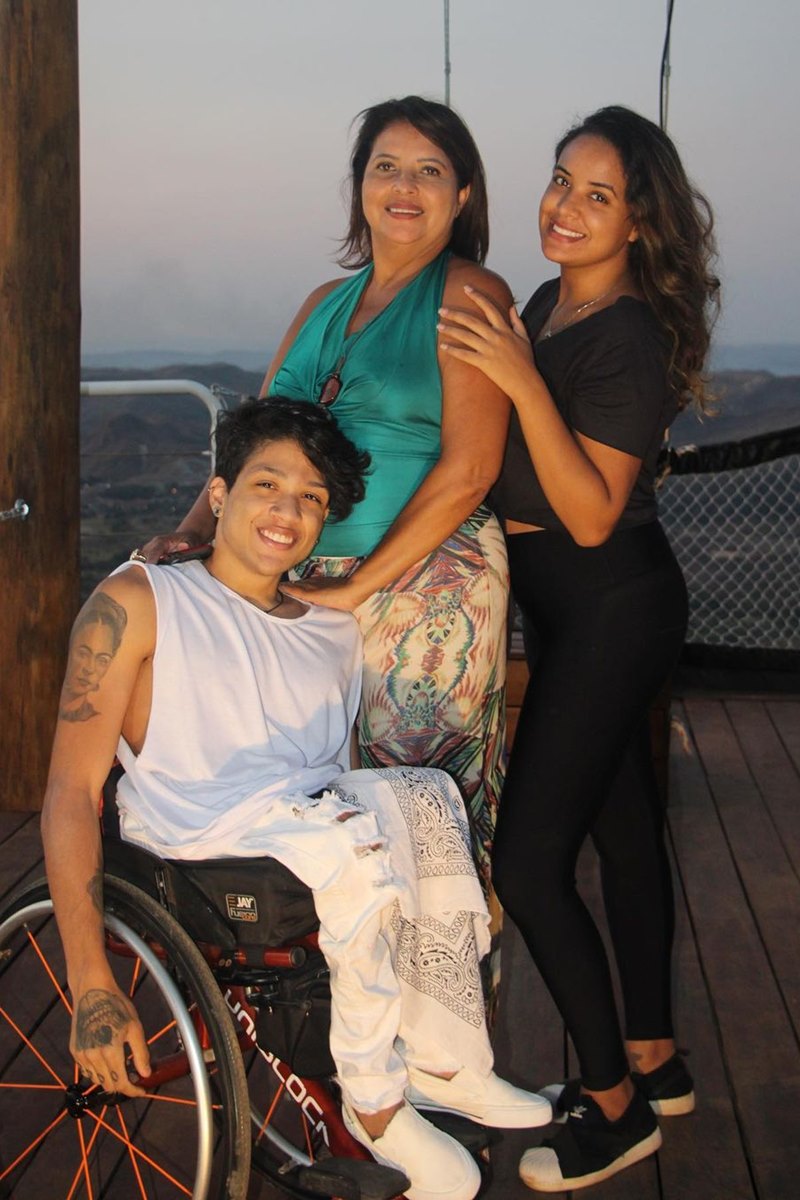 Foto colorida de homem em cadeira de rodas ao lado de duas mulheres - Metrópoles